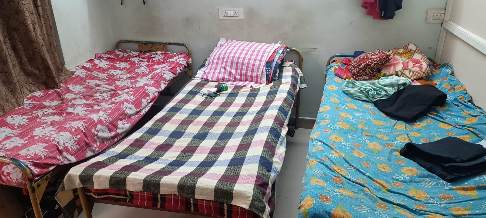 Shared hostel room with single beds at Amigos Gents Hostel, Labbipet, Vijayawada
